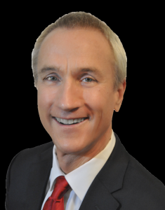 Brett Yeager, business expert and entrepreneur, smiling in a professional suit against a black background.
